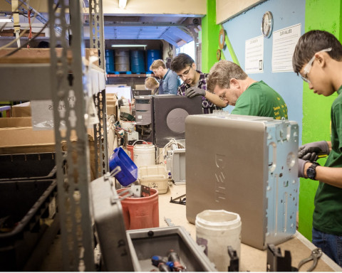 Free Geek volunteers and staff working together on computer hardware in our warehouse.