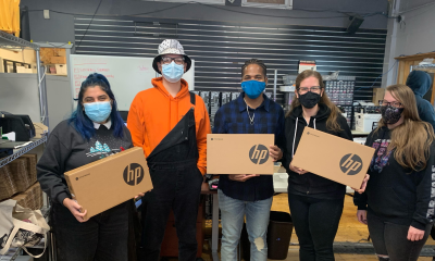 employees holding donated hp laptops