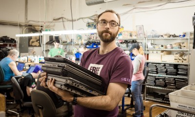 Laptop reuse and refurbishment staff holding laptops